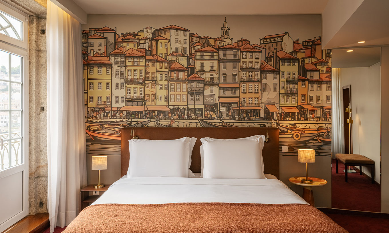 Quarto Plaza no Pestana Vintage Porto com cama de casal e mural ilustrado das fachadas ribeirinhas do Porto